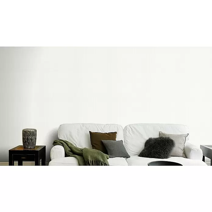 Rasch Wallton Vliestapete Makulaturvlies - Weiß, Uni, 10,05 x 0,53 m, Grammatur: 90 g/m² - Helle weiße Wand in einem modernen Wohnzimmer, hinter einem weißen Sofa mit neutralen Kissen und grünem Überwurf.