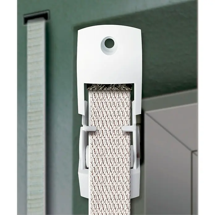 Schellenberg Duo Guía para correa de persiana Mini - L x An x Al: 6,1 x 1,5 x 2,5 cm, Apto para: Mini sistemas de persianas enrollables, Blanco - Primer plano de una guía de cordón de persiana enrollable blanca, que sujeta una banda, sobre un fondo borroso.