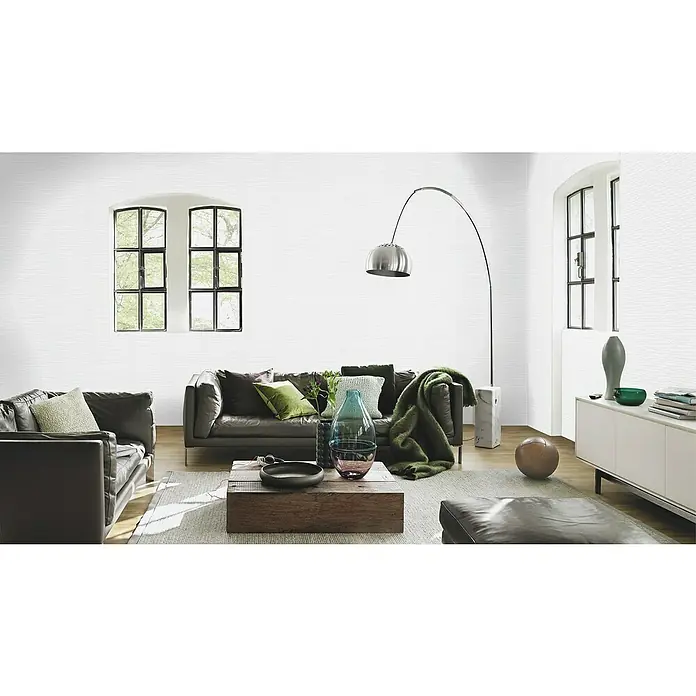 Rasch Wallton Vliestapete Mauersteine IIWeiß, Steinoptik, 10,05 x 0,53 m - Ein modernes Wohnzimmer mit einem grauen Sofa, Sesseln und Akzenten in Grün, mit stilvollem Design und einladender Atmosphäre.