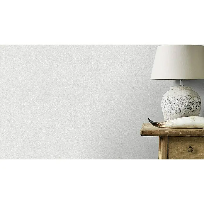 Rasch Wallton Vliestapete Klassische Putzoptik - Weiß, Uni, 25 x 1,06 m, Feine Struktur, Glänzend - Tischleuchte mit weißem Lampenschirm auf einem Nachttisch mit einem dekorativen Horn, ideal für ein stimmungsvolles Ambiente.