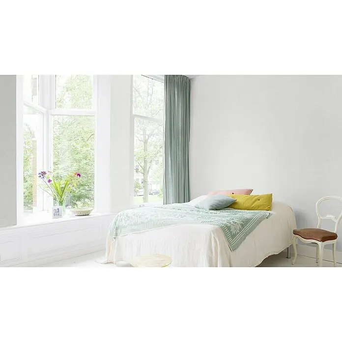 Rasch Wallton Vliestapete Gräserstruktur - Weiß, Uni, 25 x 1,06 m, Grobe Struktur, Matt - Helles Schlafzimmer mit großem Fenster und pastellfarbener Bettwäsche für eine ruhige und entspannende Atmosphäre. Weiße Holzstühle betonen den Raum.