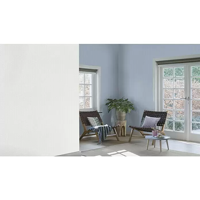 Rasch Wallton Vliestapete Strukturierte Putzoptik - Weiß, Uni, 10,05 x 0,53 m, Grobe Struktur, Glänzend - Ein Wohnzimmer mit texturierter hellblauer Tapete an den Rückwänden und einer texturierten weißen Wand links, die einen ruhigen, einladenden Raum schafft.