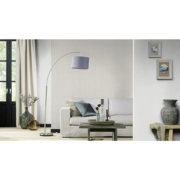 Rasch Wallton Vliestapete - Weiß, Uni, 10,05 x 0,53 m, Feine Struktur, Matt - Das Bild zeigt eine elegante Stehlampe mit einem sanften lila Lampenschirm, die über einem stilvollen Wohnbereich mit Sofa und Beistelltisch platziert ist.