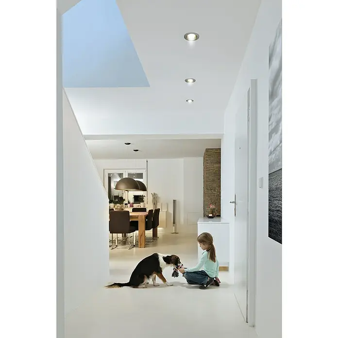 Osram Set de bombillas LED PAR16 - GU10, Blanco neutro, 350 lm, 4,5 W, 5 ud. - Un interior moderno con luces empotradas en el techo que iluminan el espacio mientras una niña juega con un perro en el pasillo. Las luces proporcionan un ambiente luminoso.