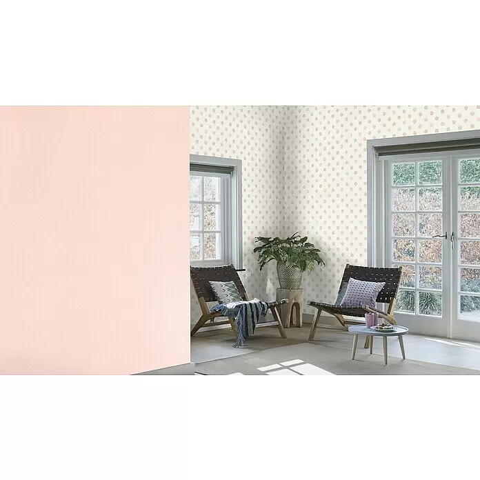 Rasch Bambino XIX Vliestapete Punkte - Rosa, Grafisch, 10,05 x 0,53 m - Hellrosa Wand neben einer Wand mit cremefarbenem Hintergrund und rosa Tupfen in einem Wohnbereich.