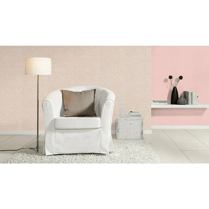 Rasch Bambino XIX Vliestapete - Rosa, Uni, 10,05 x 0,53 m - Einrichtungsidee mit einem cremefarbenen Sessel, einer Stehlampe und einem Beistelltisch auf einem Teppich. Wandgestaltung mit Mustertapete.
