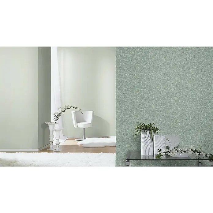 Rasch Bambino XIX Vliestapete - Salbei, Uni, 10,05 x 0,53 m - Helles Interieur mit einer gemusterten Tapete, einem modernen Stuhl und weißen Dekorationsgegenständen, die eine ruhige Raumatmosphäre schaffen.