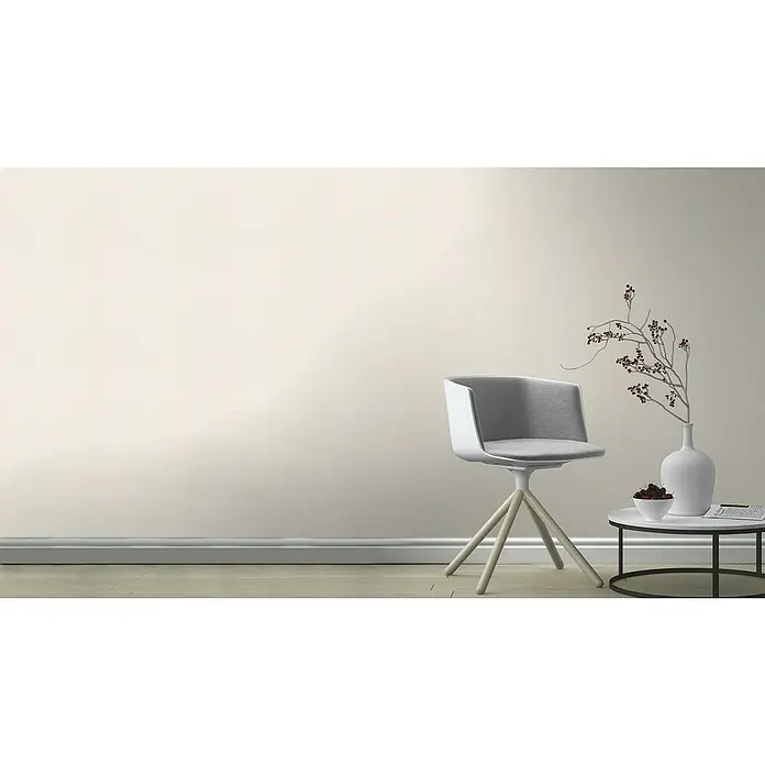 Rasch Bambino XIX Vliestapete - Creme, Uni, 10,05 x 0,53 m - Stilvolles Interieur mit einem modernen grauen Stuhl, einem Beistelltisch mit Dekoration und einer eleganten Vase.