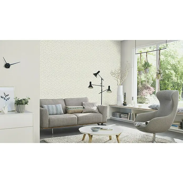 Rasch Salsa Vliestapete Textilstruktur - Hellgrau, Uni, 10,05 x 0,53 m - Ein Wohnzimmer mit einer gemusterten Tapete, einem grauen Sofa und einem modernen Sessel, der ein gemütliches Ambiente schafft.