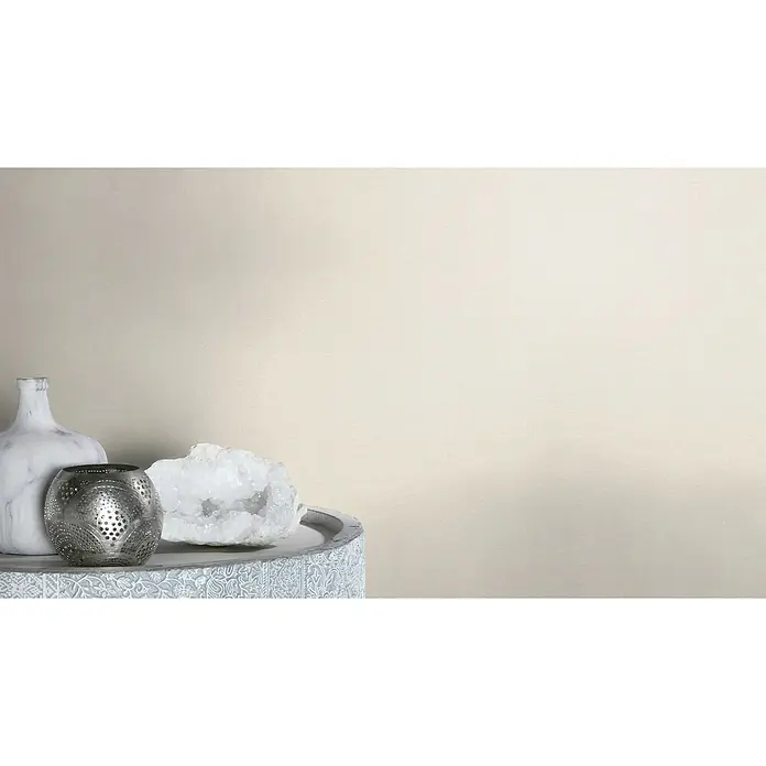 Rasch Salsa Vliestapete - Beige, Uni, 10,05 x 0,53 m - Elegante Stillleben-Komposition mit einer Marmorvase, einem silbernen Teelichthalter und einem schimmernden Quarz auf einem verzierten Tisch.