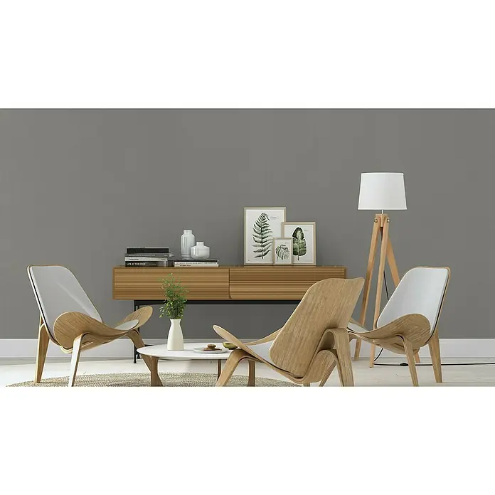 Rasch Salsa Vliestapete Textilstruktur - Dunkelgrau, Uni, 10,05 x 0,53 m - Ein modernes Wohnzimmer mit zwei Sesseln aus Holz, einem Beistelltisch mit Deko und einer Stehlampe, die ein gemütliches Ambiente schaffen.