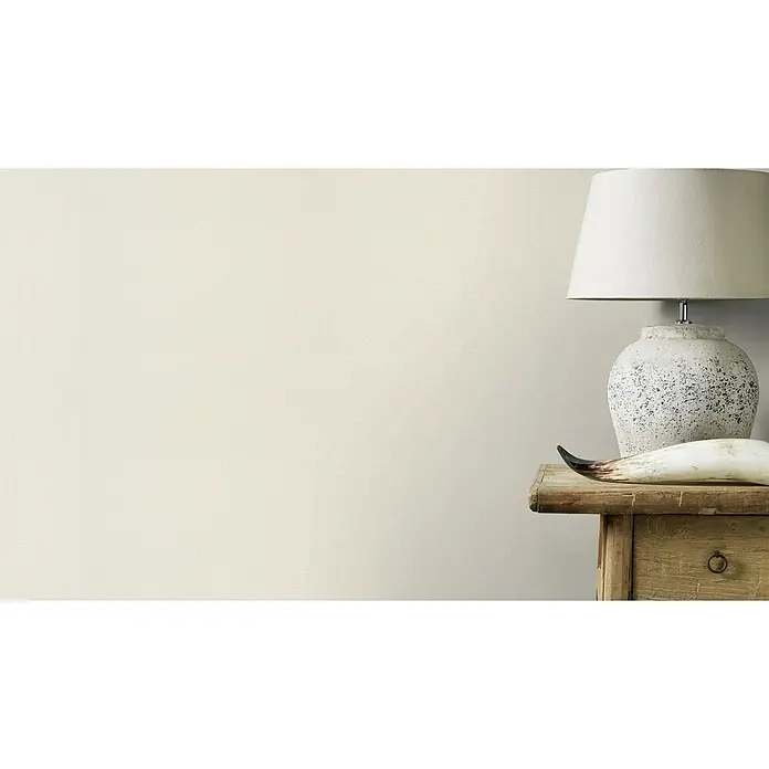 Rasch Salsa Vliestapete Textilstruktur - Altweiß, Uni, 10,05 x 0,53 m - Detailansicht einer Tischlampe mit weißem Lampenschirm, platziert auf einem rustikalen Holztisch neben einem dekorativen Horn.