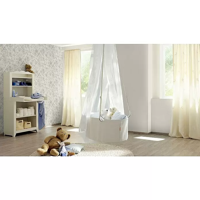 Rasch Salsa Vliestapete Textilstruktur - Altweiß, Uni, 10,05 x 0,53 m - Weißer Wickeltisch aus Holz mit Babyartikeln und einem schwebenden Stoffbettchen in einem Kinderzimmer.