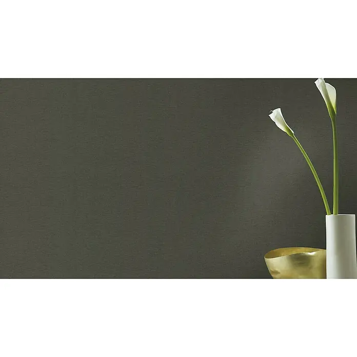Rasch Salsa Vliestapete TextilstrukturAnthrazit, Uni, 10,05 x 0,53 m - Elegante Nahaufnahme von zwei weißen Calla-Lilien in einer weißen Vase, neben einer goldenen Schale, vor einem stilvollen, dunklen Hintergrund.