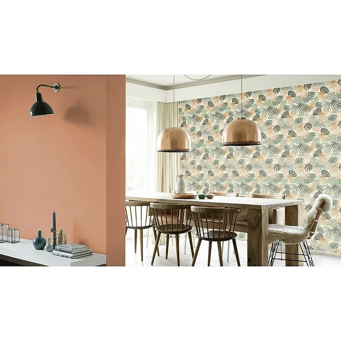 Rasch Salsa Vliestapete Blätter - Weiß-Grün, Floral, 10,05 x 0,53 m - Esszimmer mit großem Holztisch, Stühlen, Deckenlampen und einer Wand mit tropischem Blättermuster für ein stilvolles und einladendes Ambiente.