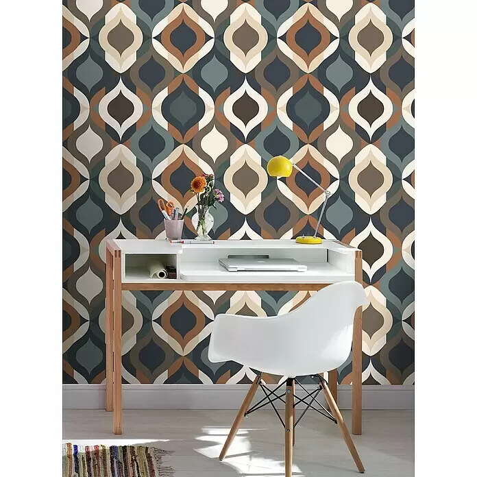 Rasch Salsa Vliestapete Retro - Grün-Braun, Grafisch, 10,05 x 0,53 m - Weißer Schreibtisch mit Holzbeinen und passendem Stuhl vor einer Retro-Musterwand. Laptop und gelbe Lampe stehen auf dem Tisch.