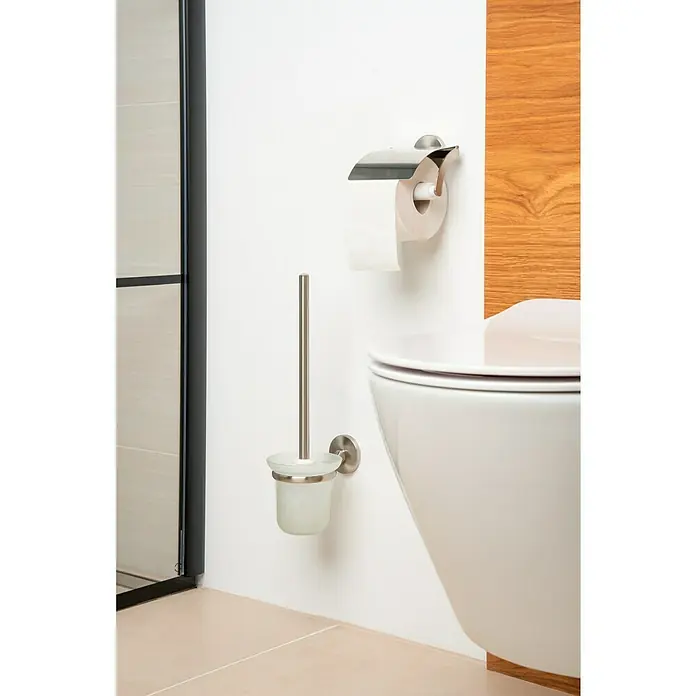 Venus Alosa Toilettenpapierhalter - Mit Deckel, Chrom, Matt - Eine Nahaufnahme einer Badezimmerecke mit einer Toilettenbürste, einem Toilettenpapierhalter und einer Toilettenschüssel.