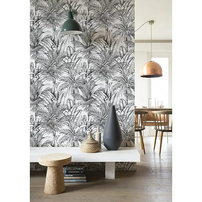 Rasch Salsa Vliestapete Palmen - Schwarz-Weiß, Floral, 10,05 x 0,53 m - Elegantes Interieur mit einer weißen Bank vor einer tropischen Tapete, dekoriert mit einer stilvollen Vase und einem Korb. Darunter Bücher für eine gemütliche Atmosphäre.