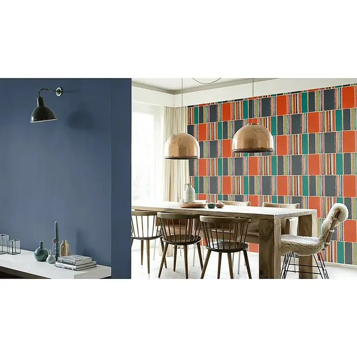 Rasch Florentine III Vliestapete - Dunkelblau, Uni, 10,05 x 0,53 m - Ein Esszimmer mit einem massiven Holztisch, Stühlen und auffälliger Wandgestaltung. Die Kupferleuchten sorgen für warmes Licht.