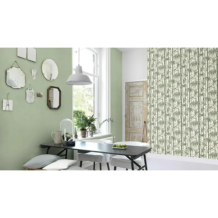 Rasch Florentine III Vliestapete - Salbei, Uni, 10,05 x 0,53 m - Eine elegante grüne Wand mit Spiegeln, kombiniert mit einer stilvollen Esstischszene, die modernes Design und Komfort vereint.