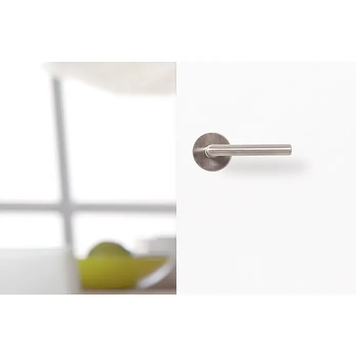 Kilsgaard Zimmertür 42/00 ohne Schlüssellochbohrung - 610 x 1.985 mm, DIN Anschlag: Rechts, Weiß lackiert, ähnlich RAL 9010, Röhrenspan - Nahaufnahme eines modernen Türgriffs aus gebürstetem Metall auf einer weißen Tür, der ein elegantes und minimalistisches Design zeigt.