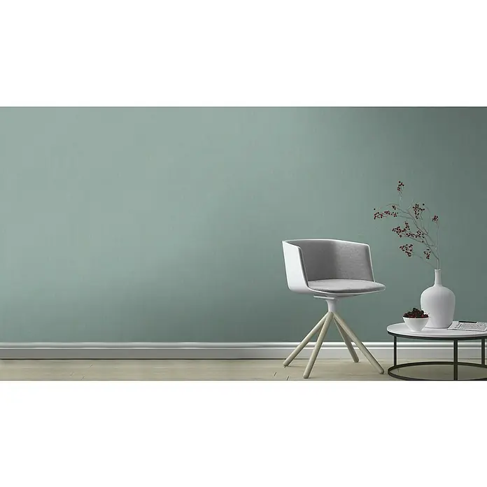 Rasch Florentine III Vliestapete - Blaugrau, Uni, 10,05 x 0,53 m - Moderner Bürostuhl in Weiß und Grau mit Beistelltisch und Dekoration vor einer mintgrünen Wand.