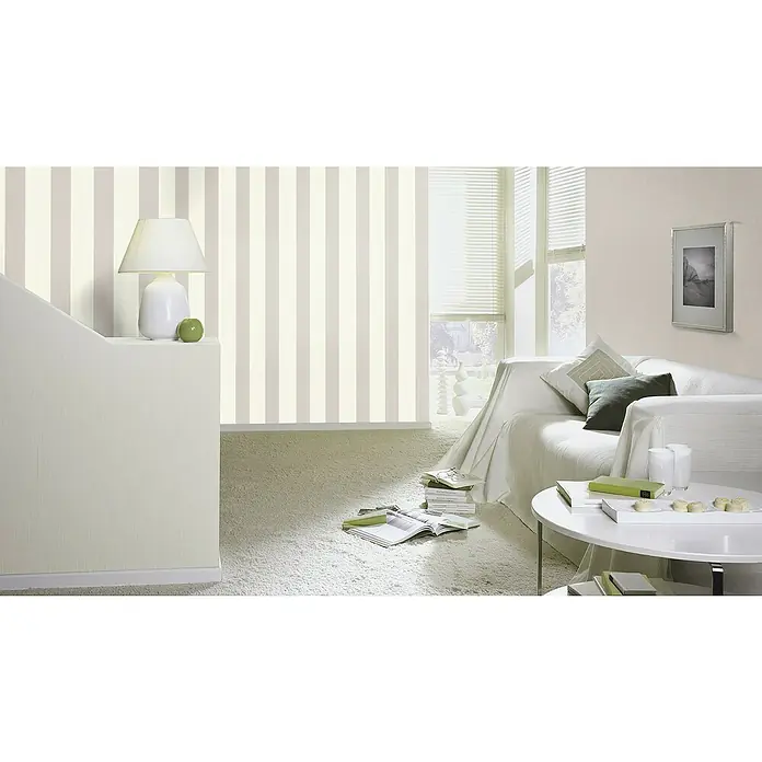Rasch Florentine III Vliestapete - Weiß-Grau, Streifen, 10,05 x 0,53 m - Wohnzimmer mit gestreifter Tapete, weißem Sofa und rundem Tisch. Die Tapete verleiht dem Raum eine elegante und stilvolle Atmosphäre.