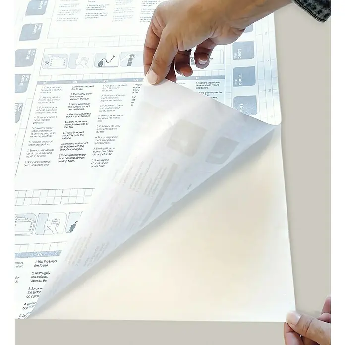 Papel pintado de vinilo adhesivo Rombo - 280 x 90 cm, Beige, Autoadhesivo - Instrucciones para aplicar la película de pared Lineafix, detallando el corte preciso, la limpieza y la aplicación de la película.