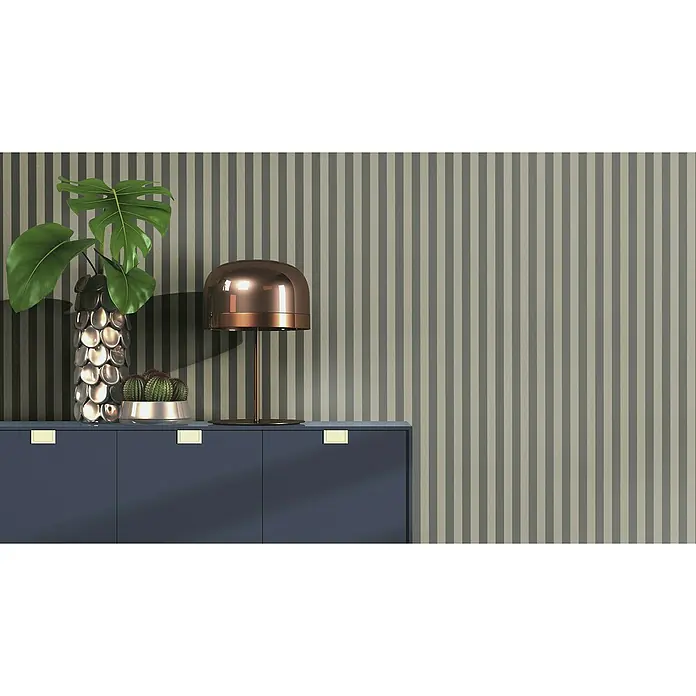 Rasch Trianon XIII Vliestapete - Schwarzgold, Streifen, 10,05 x 0,53 m - Dekoratives Interieur mit Monstera-Pflanze, Kaktus, Lampe und blauem Sideboard vor gestreiftem Hintergrund. Stilvolle Akzente für Ihr Zuhause.