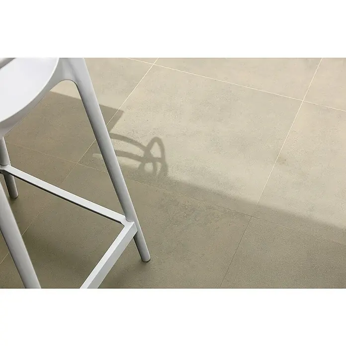 Art-Tec by Palazzo Feinsteinzeugfliese - 80 x 80 cm, Offwhite, Glänzend - Detailaufnahme eines modernen, weißen Stuhls auf Fliesenboden. Das minimalistische Design des Stuhls und der saubere Hintergrund betonen seine Eleganz.