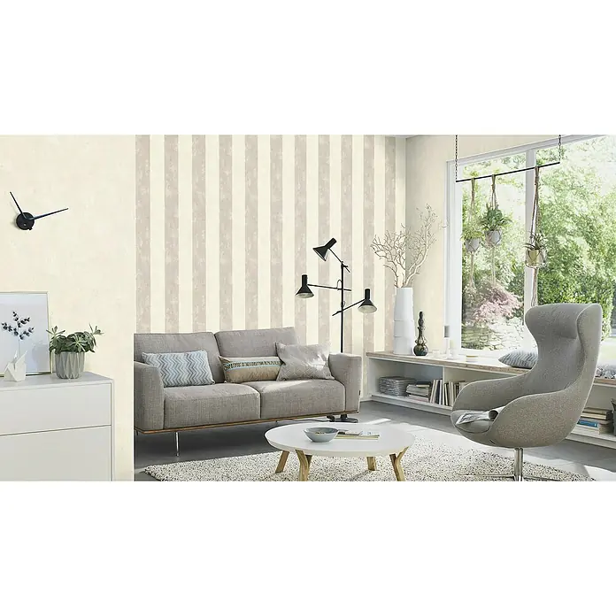 Rasch Tapetenwechsel 2 Vliestapete - Creme-Grau, Streifen, 10,05 x 0,53 m - Wohnzimmer mit gestreifter Tapete, grauem Sofa, Sessel und minimalistischem Design. Die harmonische Farbpalette schafft eine ruhige und stilvolle Atmosphäre.