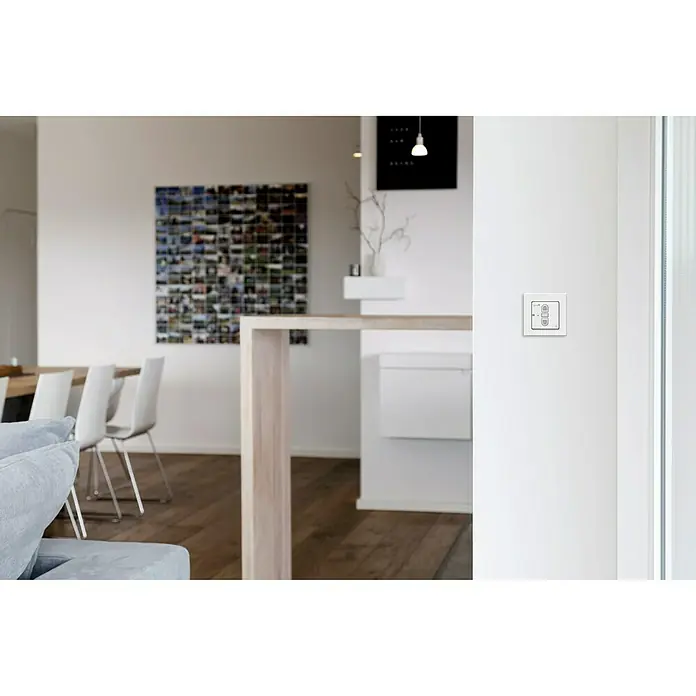 Schellenberg Smart Home Interruptor de recepción por radio - 80 x 80 x 40 mm, Blanco, Montaje enrasado - Primer plano de un interruptor de luz inteligente blanco en una pared blanca, que combina tecnología moderna con un diseño minimalista.