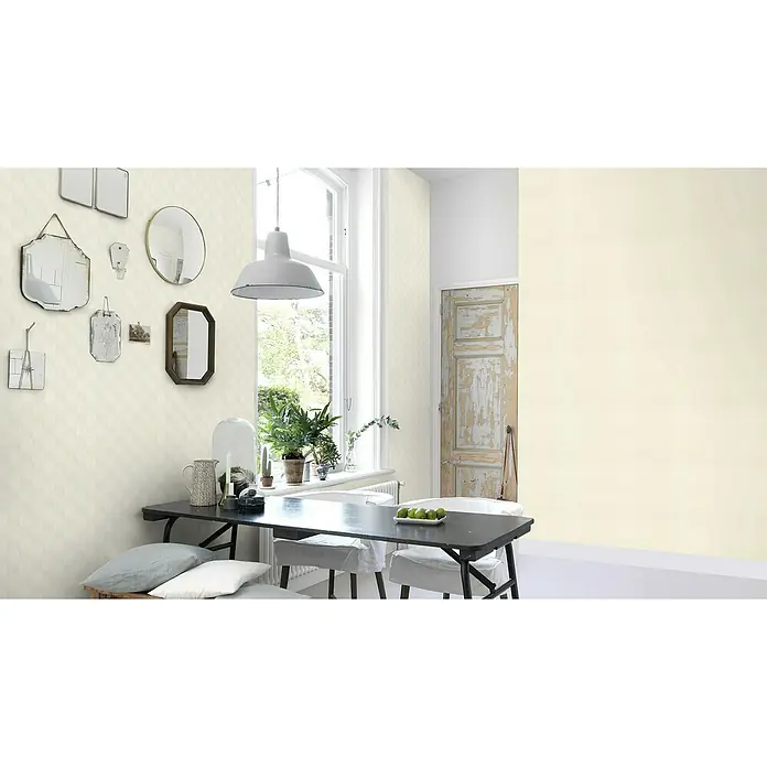 Rasch Tropical House VliestapeteAltweiß, Grafisch, 10,05 x 0,53 m - Innenraum mit Esstisch, Stühlen und Dekorationen an der Wand. Eine Lampe hängt über dem Tisch, der mit Obst und Geschirr gedeckt ist.