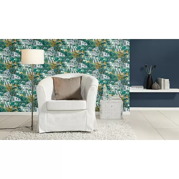 Rasch Tropical House Vliestapete - Nachtblau, Uni, 10,05 x 0,53 m - Ein weißer Sessel mit beigem Kissen steht auf einem flauschigen weißen Teppich in einem Raum mit gemusterter Tapete.