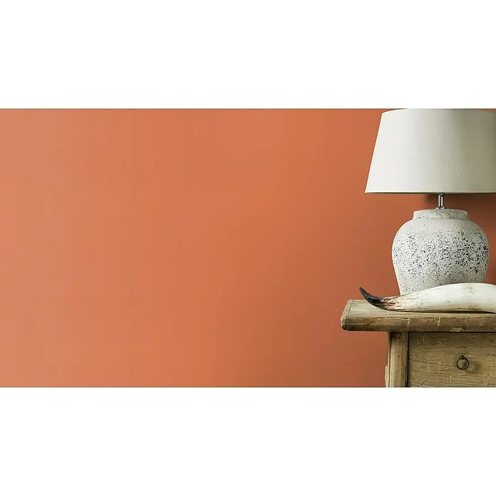 Rasch Tropical House Vliestapete - Dunkelorange, Uni, 10,05 x 0,53 m - Elegante Tischleuchte mit einem Steinfuß und einem weißen Lampenschirm, die eine warme und einladende Atmosphäre schafft.