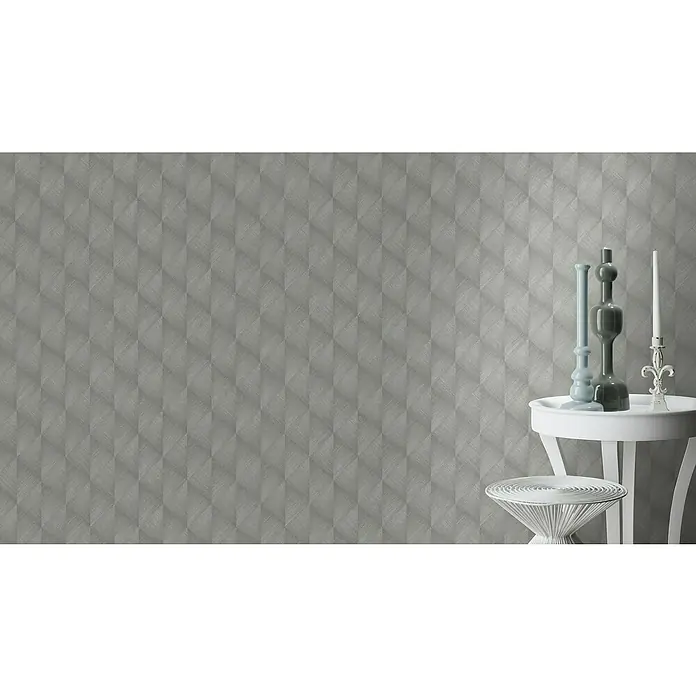 Rasch Tropical House VliestapeteSilbergrau, Grafisch, 10,05 x 0,53 m - Nahaufnahme eines Raumes mit einer grauen geometrischen Tapete, einem weißen Tisch und Kerzenständern.