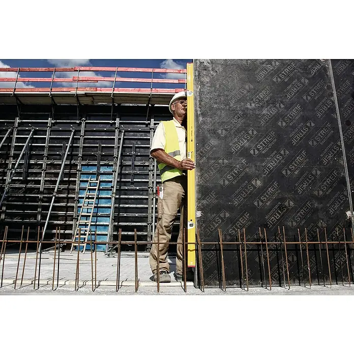 Stabila Wasserwaage Typ R-300 - Länge: 122 cm, Anzahl Libellen: 3 Stk. - Bauarbeiter mit Schutzhelm und gelber Weste überprüft mit einer Wasserwaage die Ausrichtung einer Betonwand auf einer Baustelle.