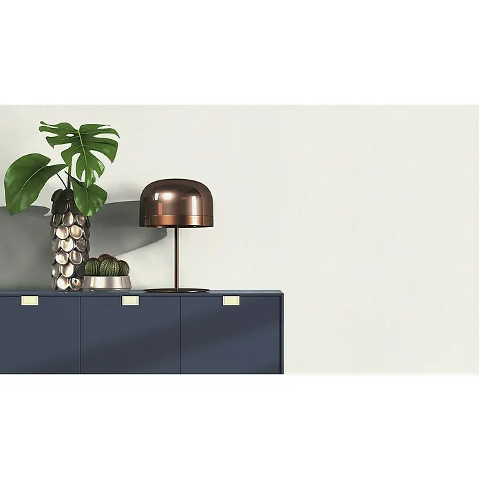 Rasch Structure Vliestapete - Weiß, Uni, 10,05 x 0,53 m - Nahaufnahme eines Sideboards mit einer Monstera-Pflanze in einer silbernen Vase, einem Kaktus und einer modernen kupferfarbenen Lampe.