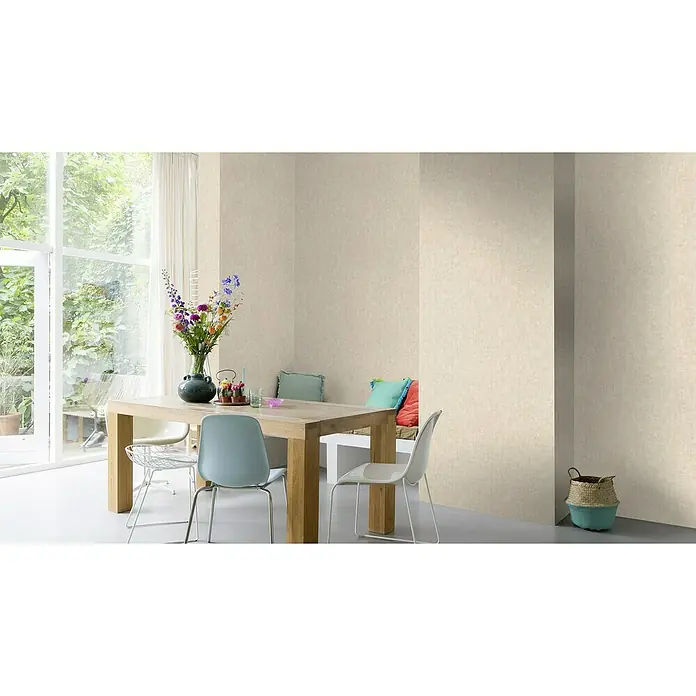 Rasch LOFT Vliestapete Uni - Beige, Betonoptik, 10,05 x 0,53 m - Ein Esszimmer mit einem Holztisch, hellblauen Stühlen und einem großen Fenster, das viel Tageslicht hereinlässt, schafft eine einladende Atmosphäre.
