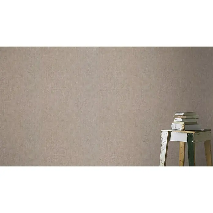 Rasch LOFT Vliestapete Uni - Braun, Betonoptik, 10,05 x 0,53 m - Bücherstapel auf einem kleinen Holztisch vor einer einfarbigen Wand, ideal für eine gemütliche Leseecke oder zur Dekoration eines Wohnraums.
