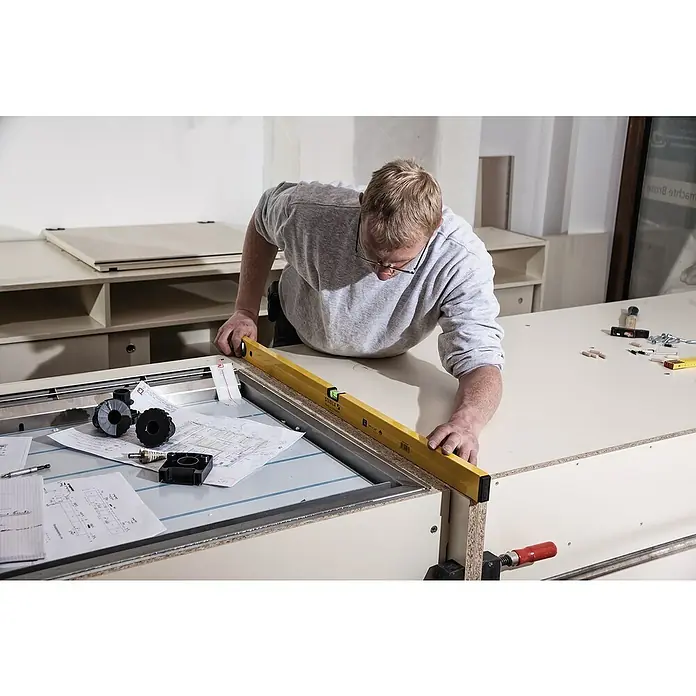 Stabila Wasserwaage Type 70Länge: 90 cm, Aluminium - Ein Mann überprüft mit einer Wasserwaage die Ausrichtung einer Konstruktion, um sicherzustellen, dass alles eben und korrekt ausgerichtet ist.