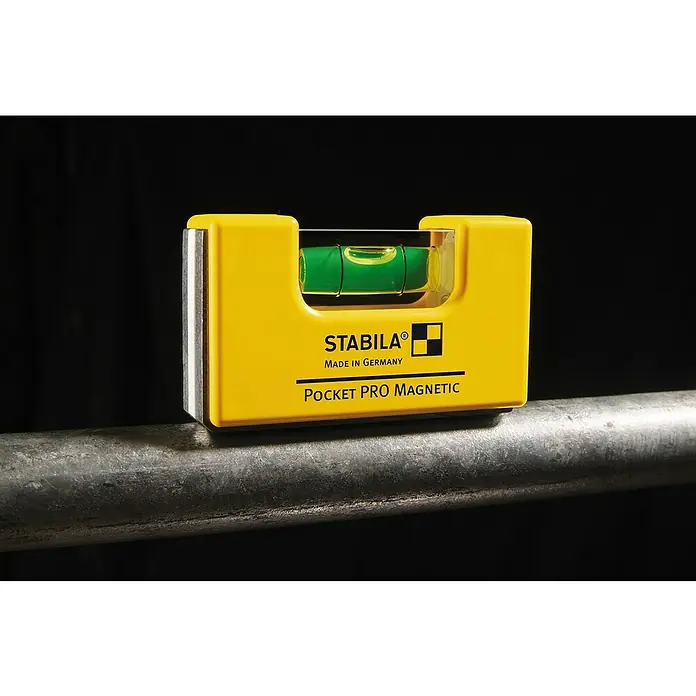 Stabila Wasserwaage Pocket Pro Magnetic - Magnet, Anzahl Libellen: 1 Stk. - Eine gelbe Stabila Pocket PRO Magnetic Wasserwaage, die auf einem Metallrohr liegt, ideal zum präzisen Ausrichten.