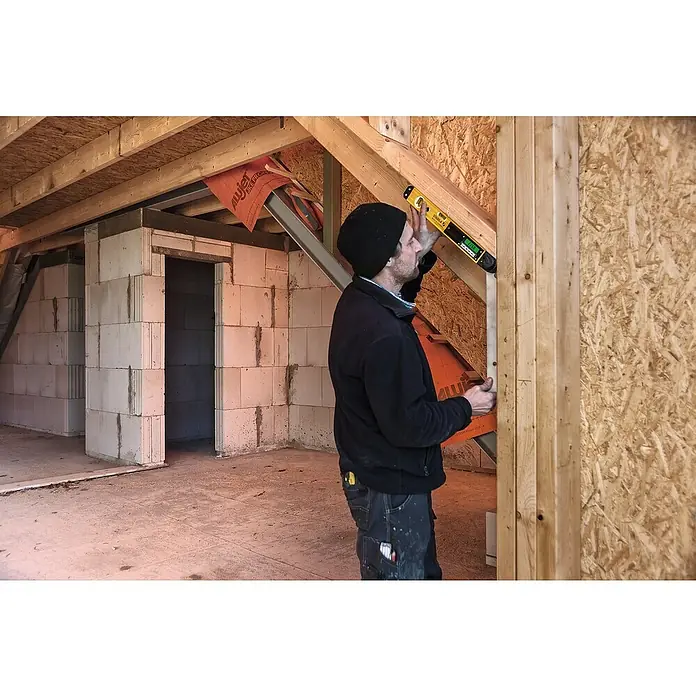 Stabila Digitaler Winkelmesser - Länge: 45 cm, Anzahl Libellen: 2 Stk. - Mann mit Wasserwaage bei Bauarbeiten. Die Wasserwaage ist gelb und schwarz und wird verwendet, um ein Holzstück auszurichten.