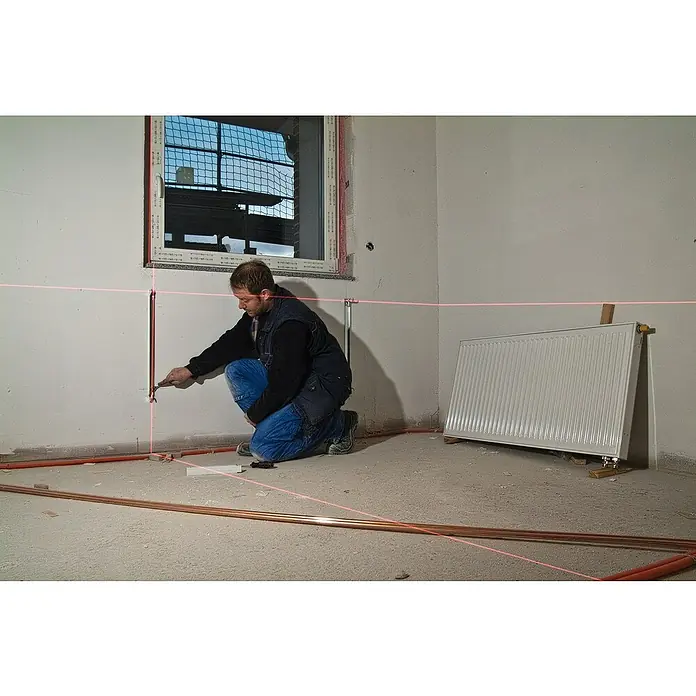 Stabila Kreuzlinienlaser LAX 300 - Max. Arbeitsbereich: 20 m, 8 -tlg. - Der Installateur richtet Heizungsrohre mit einem Laser aus, um präzise Installationen zu gewährleisten.