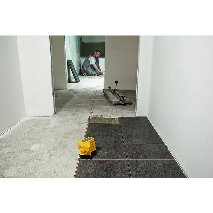 Stabila Bodenlinien-Laser FLS 90 - Ca. 15 m, 90 ° - Fliesenleger mit Laser-Wasserwaage beim Verlegen dunkler Bodenfliesen. Präzise Ausrichtung für ein ebenes Ergebnis.