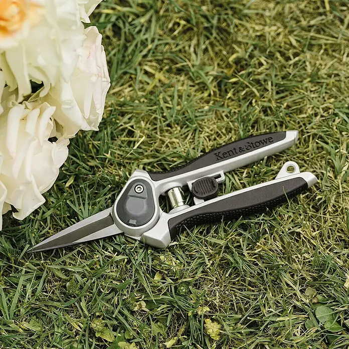 Kent & Stowe Gartenschere Eversharp Blumen - Ausführung: Spitze Klingen - Nahaufnahme einer Kent & Stowe Rosenschere auf einer Rasenfläche mit Blumen. Ideal für präzise Rosenschnitte im Garten.