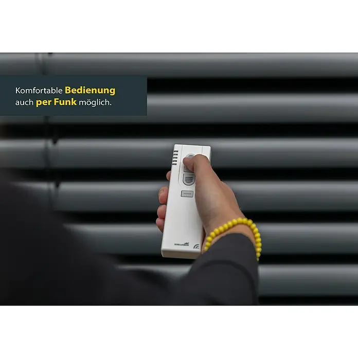 Schellenberg Raffstore Express - 140 x 260 cm - Person bedient Jalousie mit einer Fernbedienung. Moderne Steuerung für komfortable Bedienung der Jalousien.