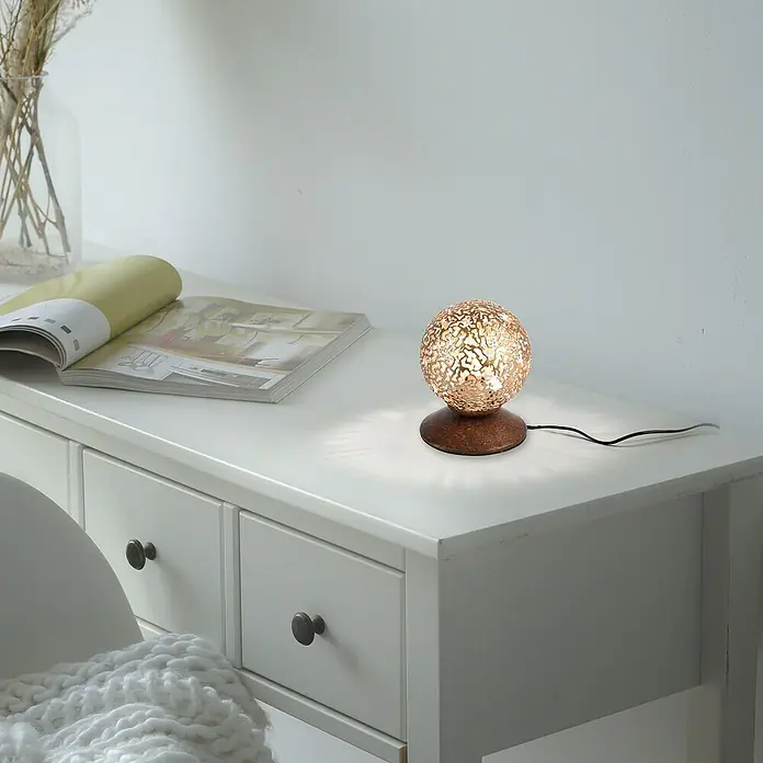 Paul Neuhaus Greta Lámpara de sobremesa redonda - 40 W, Ø x Al: 100 mm x 13 cm, Oro, G9 - Lámpara esférica decorativa con un diseño de filigrana sobre una cómoda blanca, creando una luz ambiental y cálida.