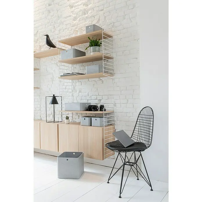 Curver Aufbewahrungsbox Beton ML x B x H: 34 x 24 x 12 cm, Material: Kunststoff, Beton - Ein modernes Wohnzimmer mit einem Regalsystem, einem Sideboard und einem schwarzen Drahtstuhl mit einem Laptop.