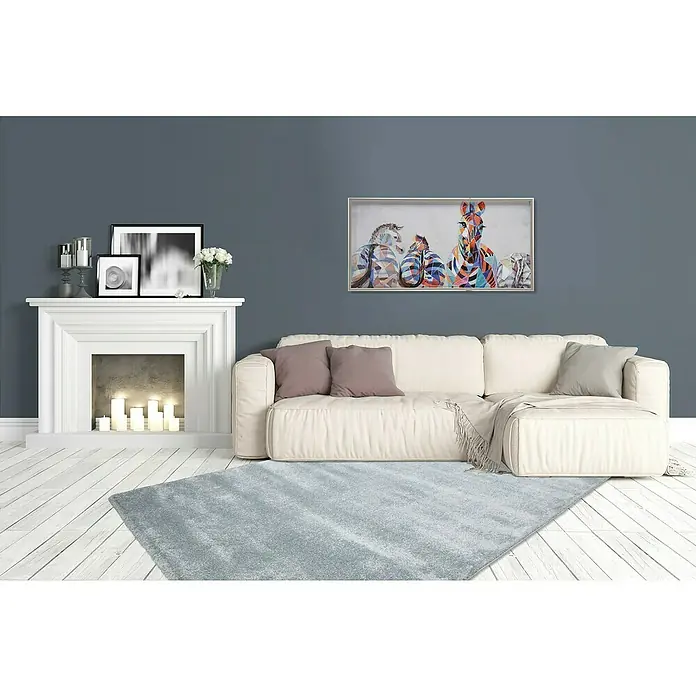 Kurzflorteppich Softtouch 700 - Pastell-Blau, 230 x 160 cm, 100 % Polypropylen (Flor) - Ein stilvolles Wohnzimmer mit einem weichen, grauen Teppich, einem weißen Sofa und einem modernen Gemälde an der Wand. Die perfekte Ergänzung für Ihr Zuhause.